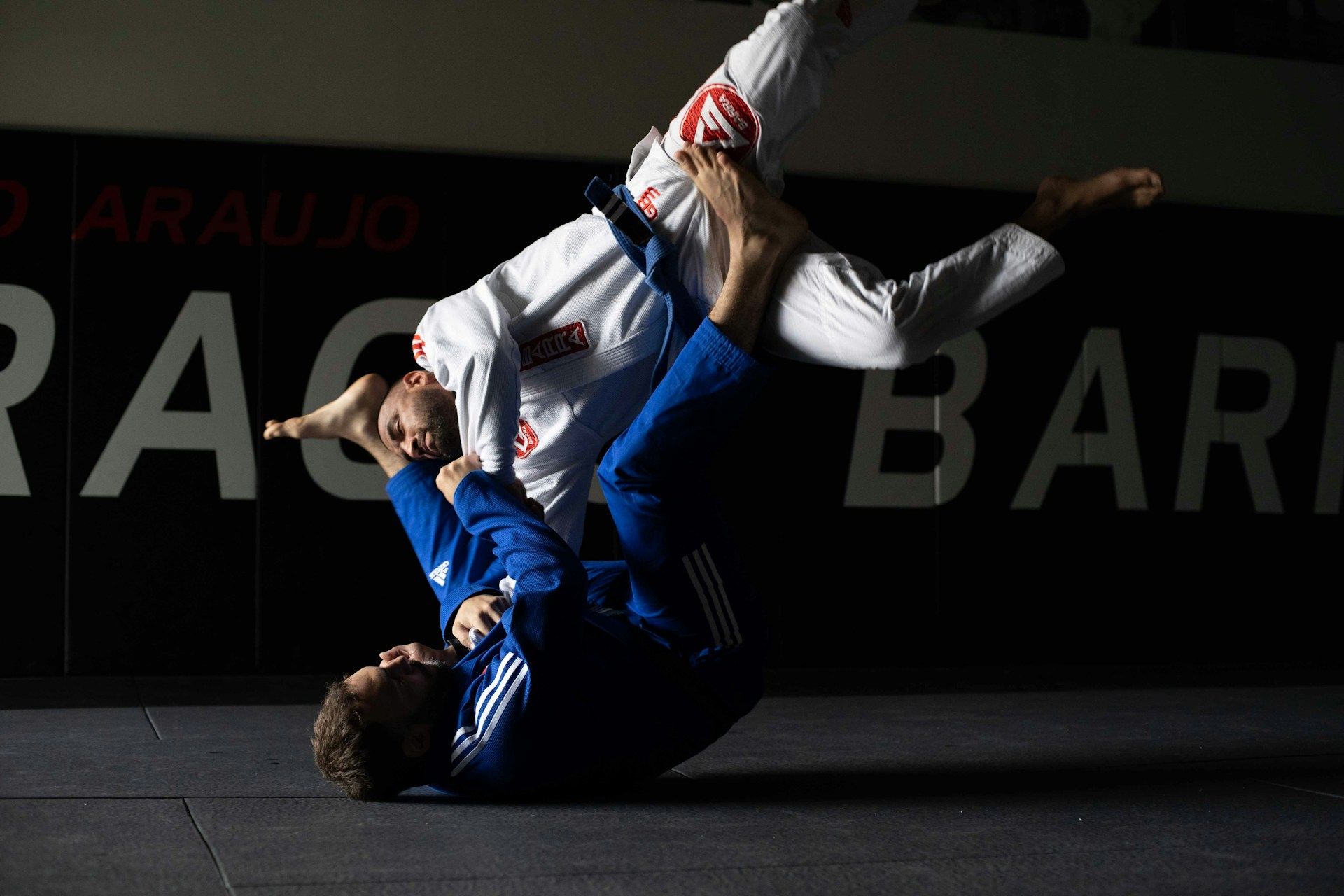 Extreme close-up of a high-quality heavy weave BJJ gi with a red embroidered patch on the shoulder